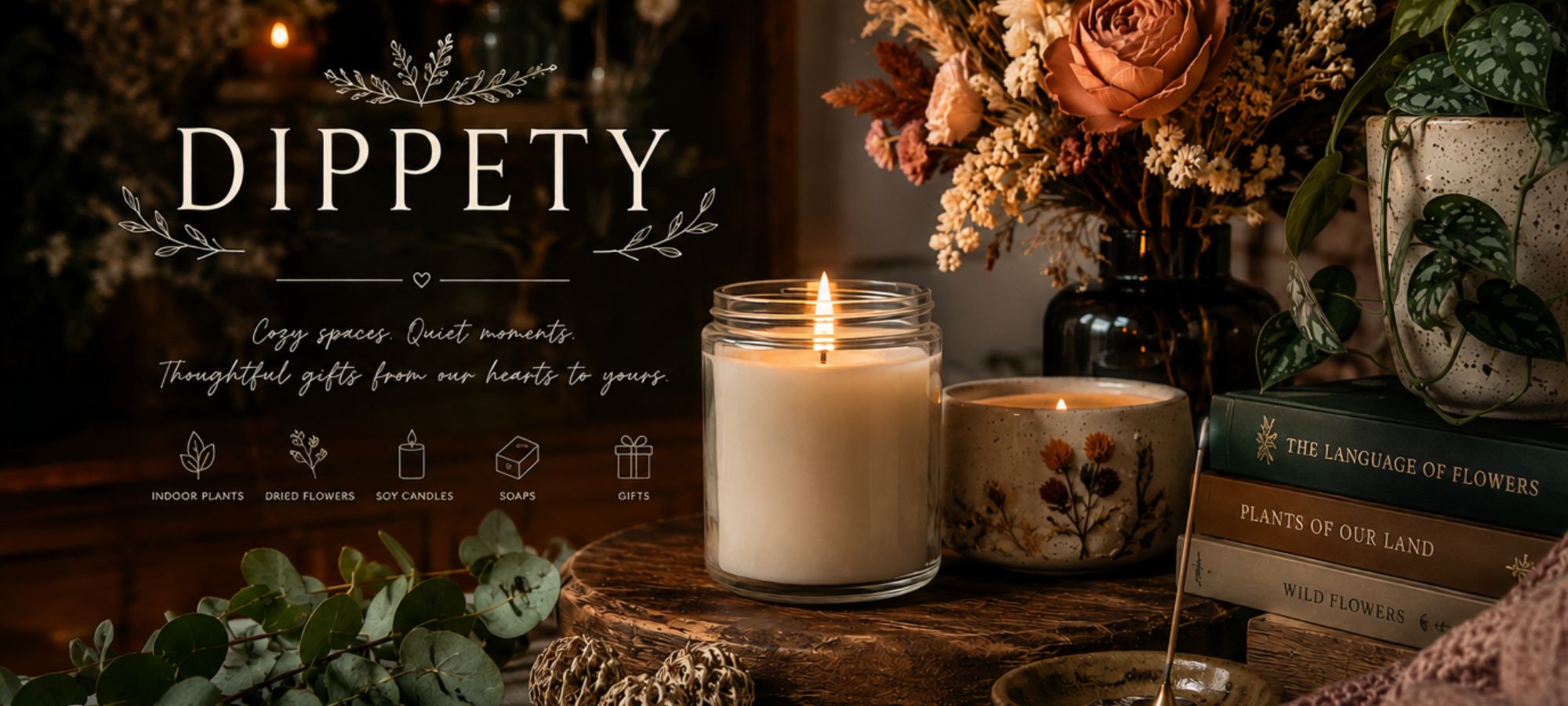 A styled product scene for Dippety candles showing a lit white candle in a clear glass jar, a small floral ceramic candle holder, dried flowers in a vase, books, and greenery on a rustic wooden surface. The brand name DIPPETY appears prominently on the left with decorative text.